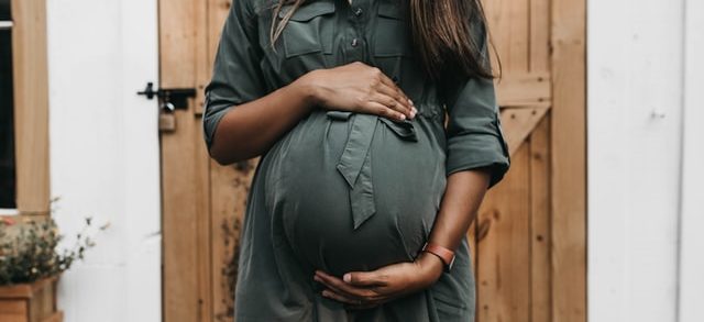 A pregnant woman holding her tummy