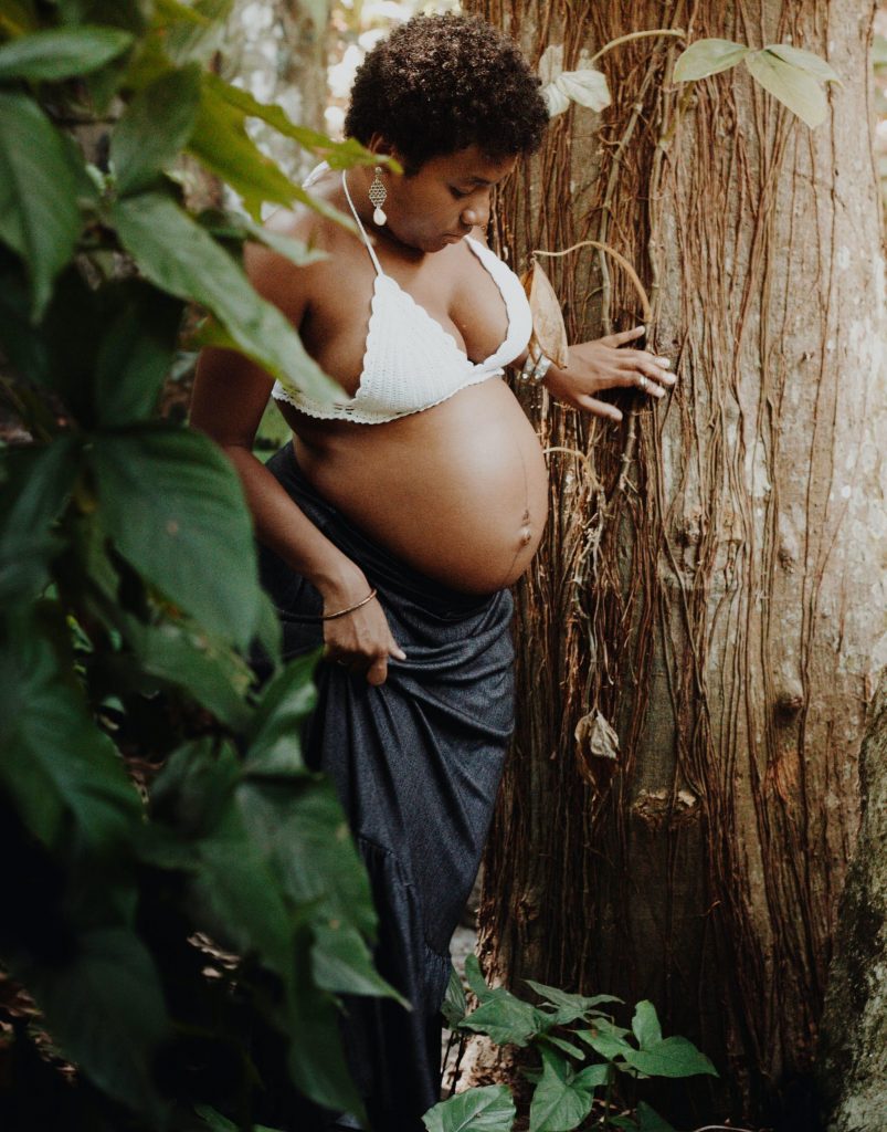 Fertility and Pregnancy Wellness: Pregnant black woman in the forest