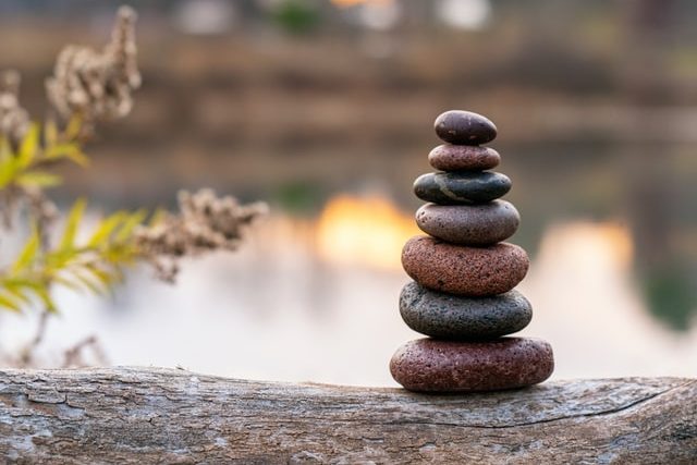 Acupuncture: Zen stones stacked on top of fallen tree