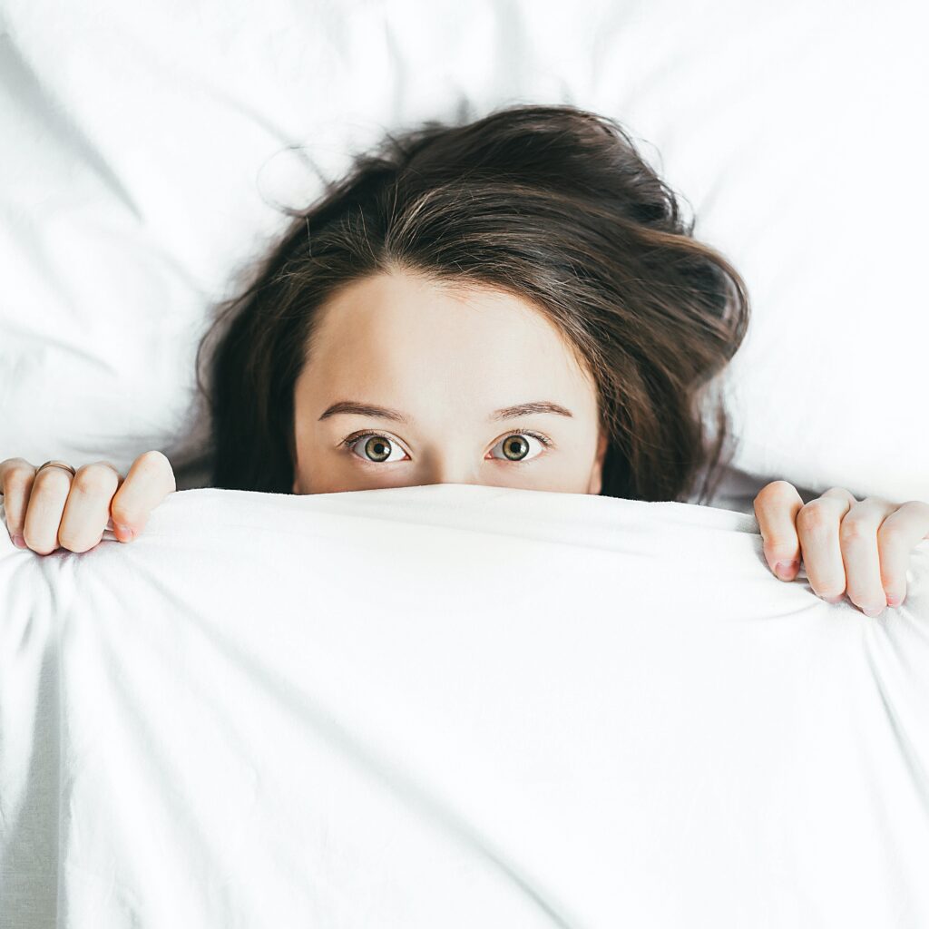 Acupuncture for insomnia. A women lies wide awake in her bed at night suffering with insomnia.