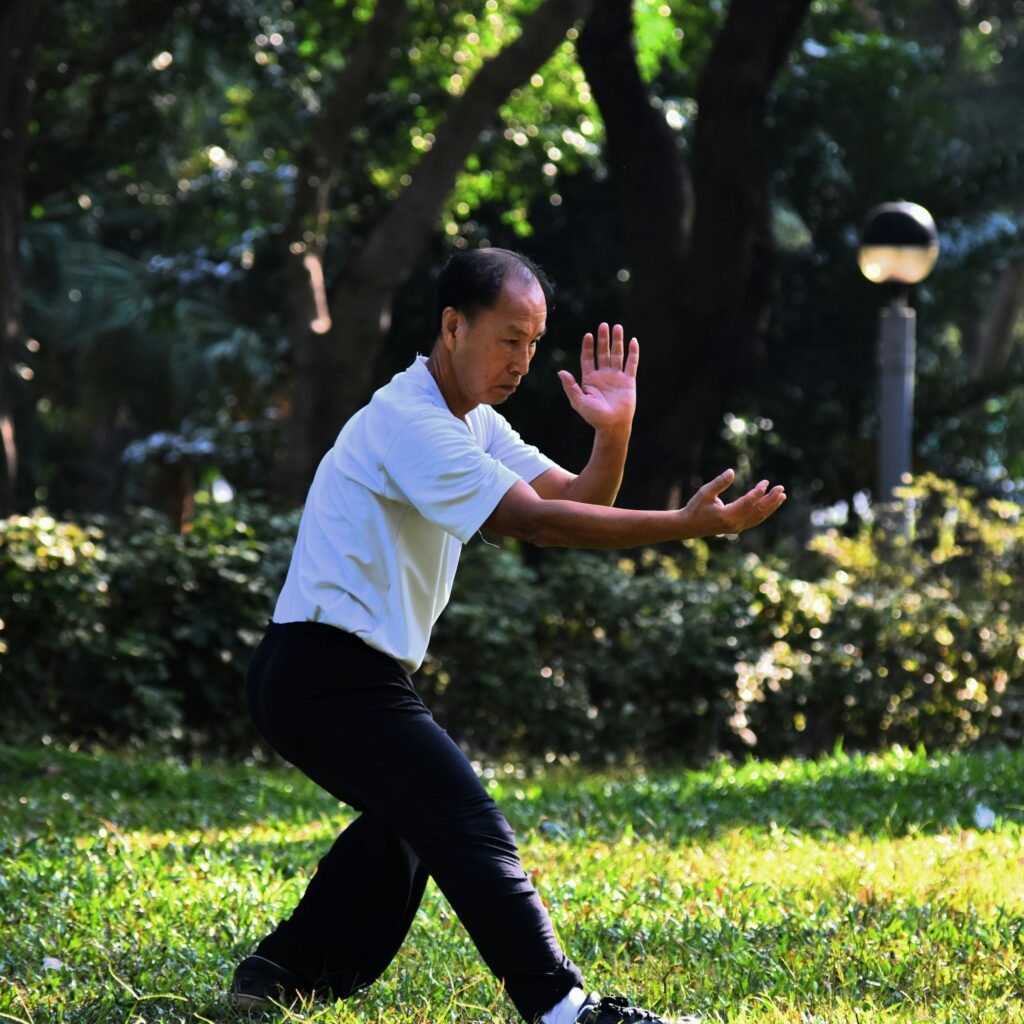 a man practices tai qi in a park